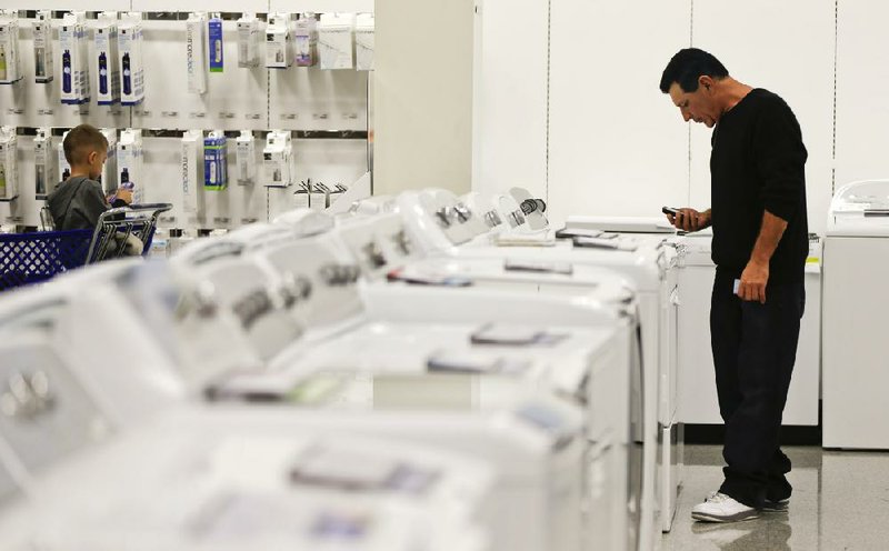 In this Friday, Nov. 23, 2012, photo, a man examines a row of washers and dryers while shopping at a Sears store in Henderson, Nev. U.S. companies increased their orders for long-lasting manufactured goods in November, with a second consecutive monthly gain in a key category that reflects businesses’ investment plans.  The Commerce Department reported Friday, Dec. 21, 2012, that orders for durable goods rose a seasonally adjusted 0.7 percent in November, compared to October, when orders had risen 1.1 percent. (AP Photo/Julie Jacobson)