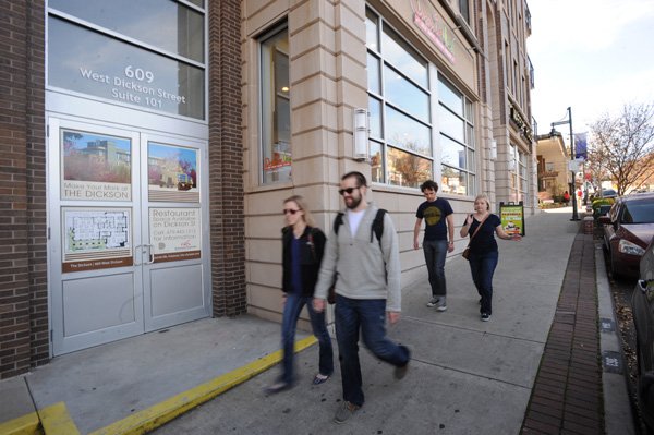 Pedestrians walk past the entrance to The Dickson, a development on West Dickson Street in Fayetteville on Nov. 29. Bill Underwood, a Fayetteville jeweler, partnered with several others to build the high-rise condominium project but said it wasn’t as profitable as he had hoped. 