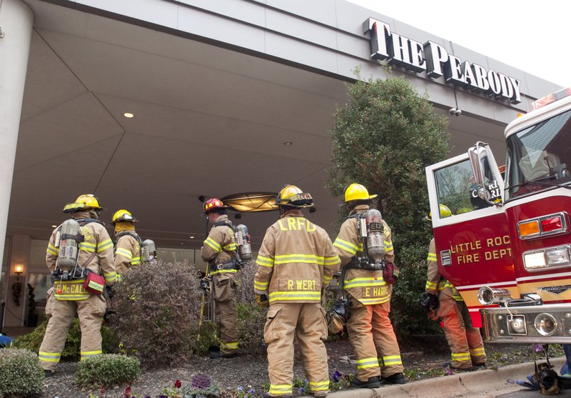 Members of the Little Rock fire department wait for their next assignment outside of the Peabody Hotel early Tuesday morning. A kitchen fire inside the hotel destroyed two full kitchens and caused the lobby to fill with smoke. No injures were reported.