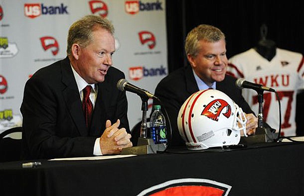 New Western Kentucky head coach Bobby Petrino, left, responds to a question as athletic director Todd Stewart smiles during an NCAA college football news conference, Monday, Dec. 10, 2012, in Bowling Green, Ky. The 51-year-old was fired by Arkansas in April for a "pattern of misleading" behavior following an accident in which the coach was injured while riding a motorcycle with his mistress as a passenger but now wants to make the most of his second chance. (AP Photo/The Daily News, Joe Imel)