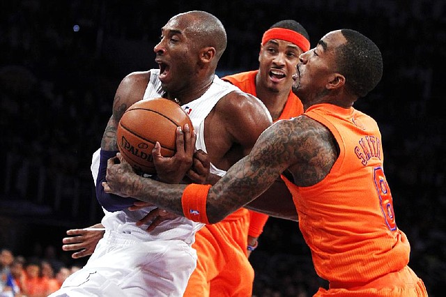 Los Angeles Lakers guard Kobe Bryant, left, is fouled by New York Knicks guard J.R. Smith, right, as forward Carmelo Anthony, center, watches during the first half of their NBA basketball game in Los Angeles, Tuesday, Dec. 25, 2012. (AP Photo/Alex Gallardo)