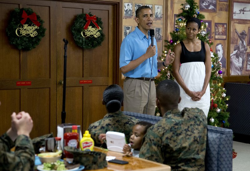 President Barack Obama speaks as first lady Michelle Obama listens during a visit with members of the military and their families in Anderson Hall at Marine Corp Base Hawaii on Tuesday, Dec. 25, 2012, in Kaneohe Bay, Hawaii. The first family is in Hawaii for a holiday vacation. 