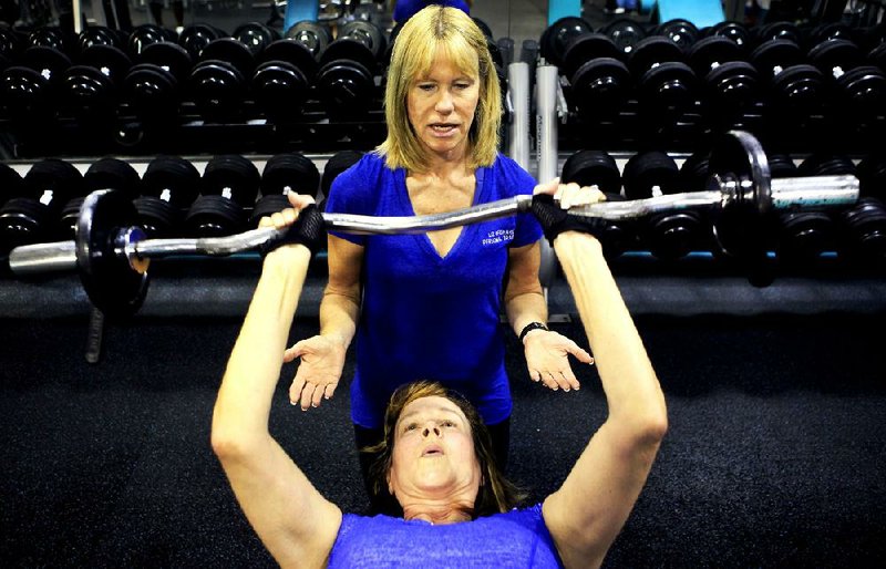 Personal Trainer Elizabeth Reighard spots for client Mary Smith as she runs her through a workout at the North Myrtle Beach Aquatic Center in North Myrtle Beach, South Carolina, Monday, December 17, 2012. (Steve Jessmore/Myrtle Beach Sun-News/MCT)