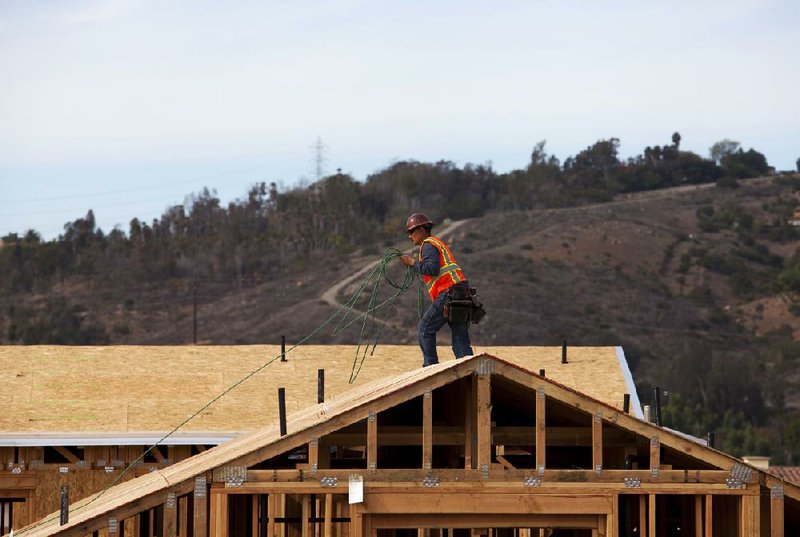A worker installs roofing material on a house under construction at Davidson Communities LLC's Arista at The Crosby development in Rancho Santa Fe, California, U.S. on Friday, Dec. 21, 2012. New home sales climbed to a 380,000 annual rate in November, the most since April 2010, according to the median forecast of 60 economists surveyed by Bloomberg before Dec. 27 figures from the Commerce Department. Photographer: Sam Hodgson/Bloomberg