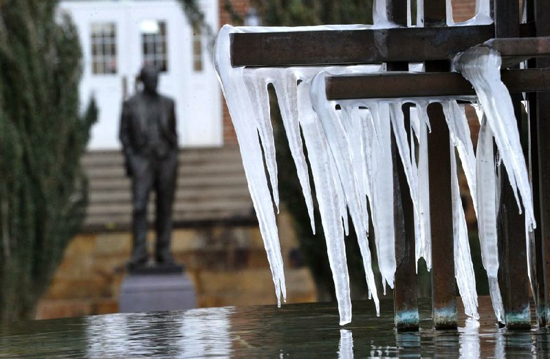 NWA Media/MICHAEL WOODS  --12/27/2012--  The J. William Fulbright statue stands alone in the cold as icicles form on the Peace Fountain next to Old Main in the University of Arkansas campus Thursday morning.  With most students and faculty home for the holidays the University is running on minimal staff during the winter break.