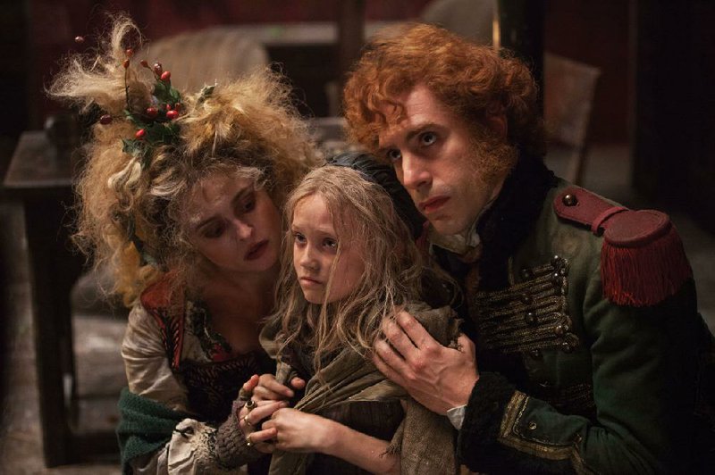 Madame Thenardier (Helena Bonham Carter), Cosette (Isabelle Allen) and Thenardier (Sacha Baron Cohen) star in Tom Hooper’s Les Miserables. 