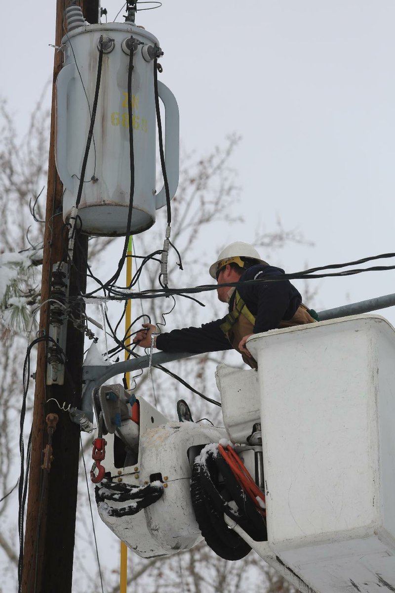 Brandon Wilson, an employee of North Little Rock Electric, reconnects power to homes near West 36th and Gum streets in North Little Rock on Thursday. 
