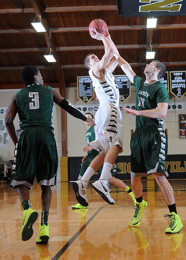 Nick Smith of Bentonville goes up for a shot Thursday as Jeff Leeson of St. Joseph-Lafayette (Mo.) attempts to block it during the Neosho Holiday Classic. 