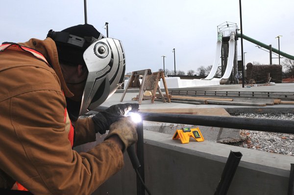 Everett Hice welds railings Thursday near one of the water slides at the Rogers aquatic center. 