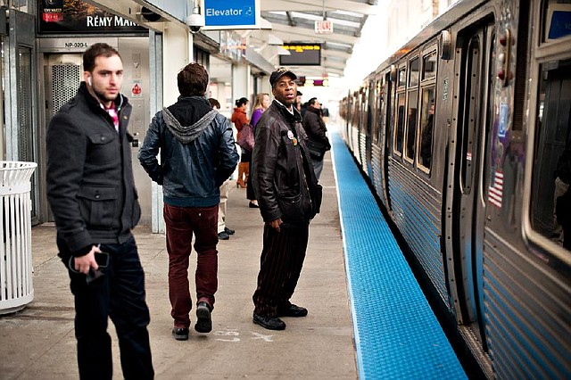 Tyree Johnson, 44, watches a slow-moving train pass as he makes his way to work at a McDonald’s in Chicago. Johnson has worked at various McDonald’s restaurants for two decades but still makes minimum wage. 