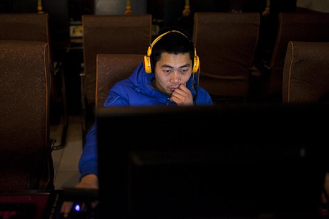 A man uses a computer Friday at an Internet cafe in central Beijing. Internet users in China now face tougher restrictions. 