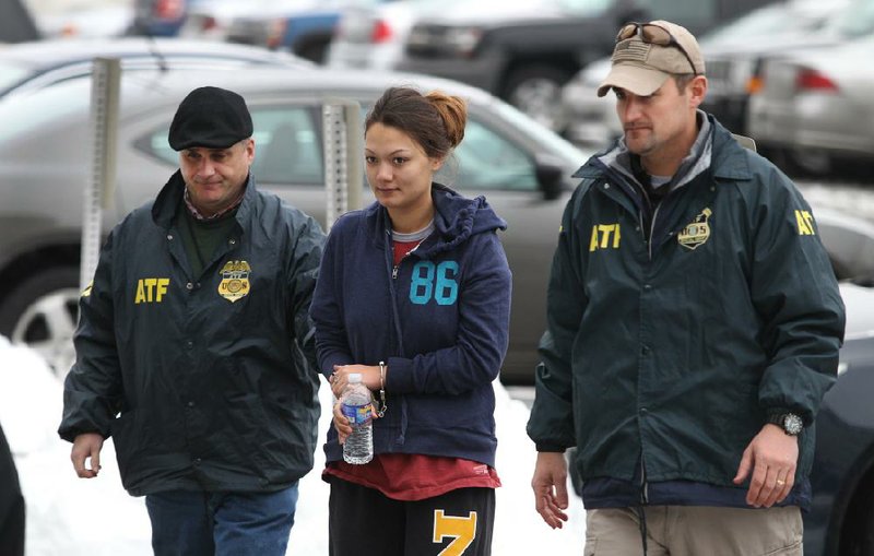 Officers escort Dawn Nguyen into the Federal Building in Rochester, N.Y., on Friday. She faces charges regarding the guns used in the Christmas Eve ambush slaying of two volunteer firefighters responding to a house fire in Webster, N.Y. 