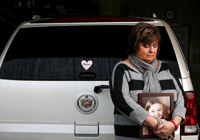 Judy Neiman holds a photo of her daughter, Sydnee, in front of her 2006 Cadillac Escalade three days before Christmas at her home in West Richland, Wash. Sydnee died in late 2011 after Neiman accidentally backed over her with the SUV. 