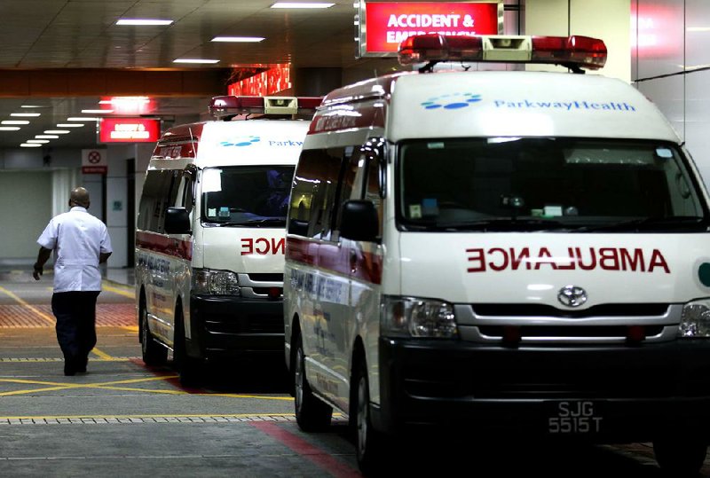 Ambulances park outside the emergency entrance of Mount Elizabeth Hospital in Singapore late Friday, where a woman who was gang-raped and beaten earlier this month died. 