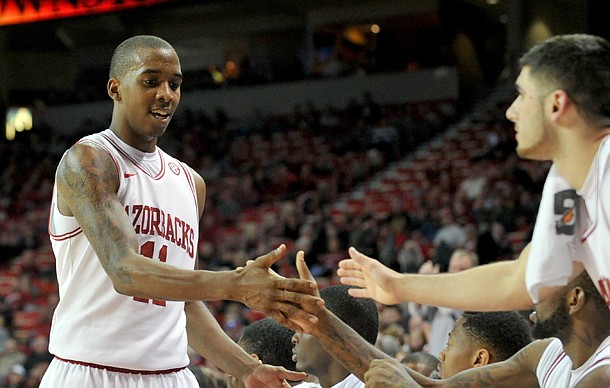 Arkansas guard BJ Young gets high fives from his teammates as he leaves the game late in the second half of Saturday night's game against Northwestern State. Young and Hunter Mickelson each finished with a career-high 13 rebounds.