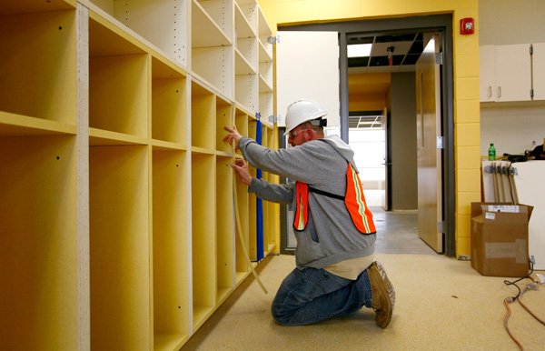 Tim Devall with Architectual Concepts works Friday on the cubbies inside one of the classrooms on at Janie Darr Elementary School in Rogers. 