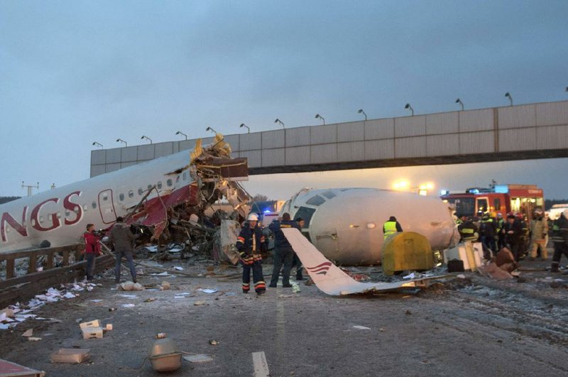 Rescuers work around the wreckage of a Tu-204 jetliner Saturday after it broke apart while landing at Vnukovo Airport in Moscow. 