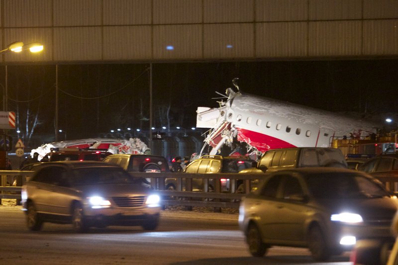 Cars travel past the wreckage of a plane that careered off the runway at Vnukovo Airport in Moscow, Saturday, Dec. 29, 2012. A Tu-204 aircraft belonging to Russian airline Red Wings careered off the runway at Russia's third-busiest airport on Saturday, broke into pieces and caught fire, killing several people. 