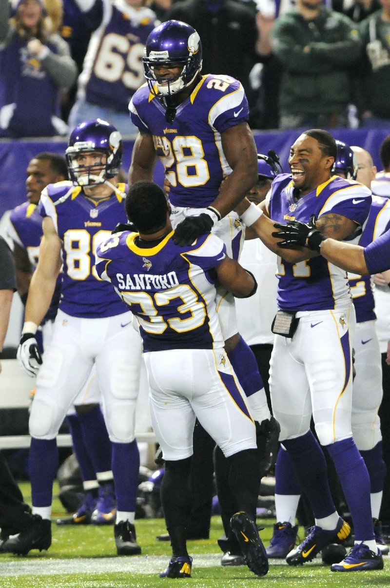 Minnesota Vikings running back Adrian Peterson (center,top) became the seventh player to rush for 2,000 yards in a season Sunday afternoon against the Green Bay Packers in Minneapolis. Peterson ÿnished with 199 yards and a touchdown in the Vikings’ 37-34 victory over the Packers, leaving him nine yards shy of breaking Eric Dickerson’s single-season record of 2,105 set in 1984. 