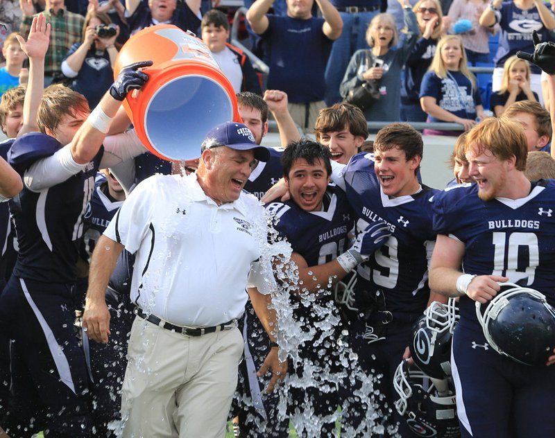  Greenwood coach Rick Jones gets drenched in ice water by his players Saturday after winning the 6A state championship football game.