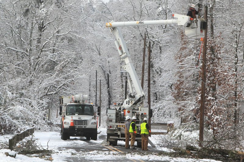 An Entergy Arkansas Inc., crew works to restore power to customers on Whittington Avenue near the entrance to Hot Springs National Park, Thursday, Dec. 27, 2012, in Hot Springs, Ark.