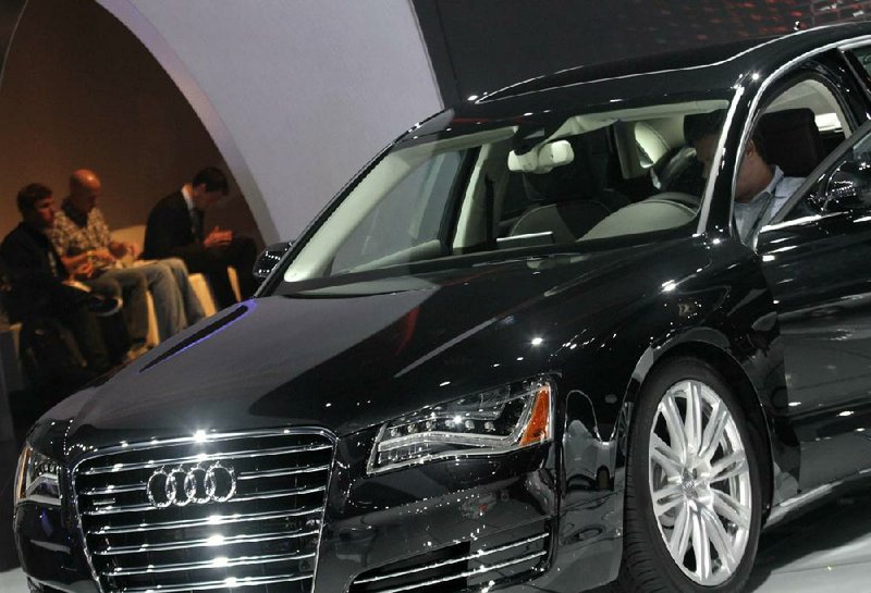 A visitor sits in an Audi sedan at the Los Angeles Auto Show in November. The automaker is planning to spend big to cut into rival BMW’s luxury sales. 