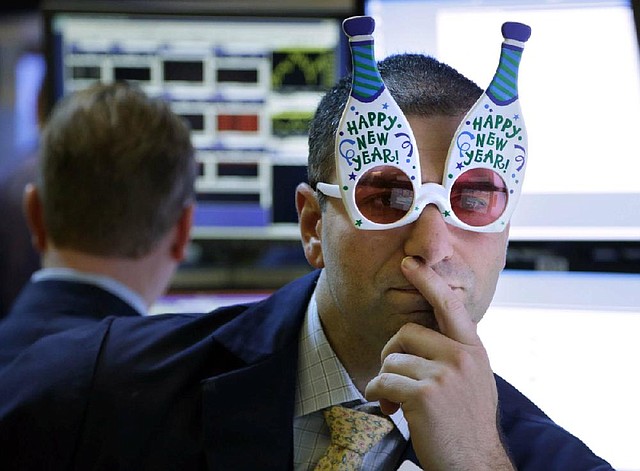 A trader wearing “Happy New Year” glasses works on the floor at the New York Stock Exchange in New York on Monday. 