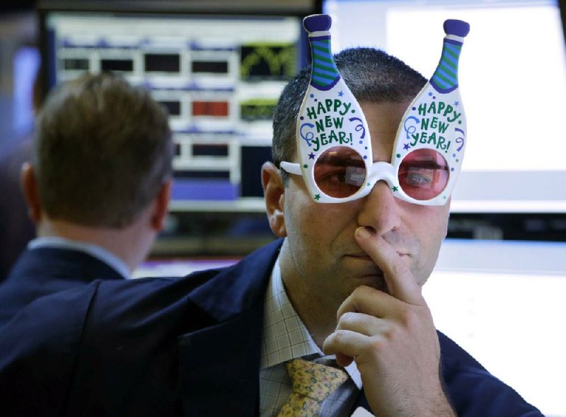 A trader wearing “Happy New Year” glasses works on the floor at the New York Stock Exchange in New York on Monday. 