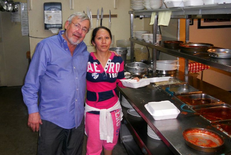 Ken Shivey, owner of The Villa, with employee Lourdes Melo, share a hug in the now-closed restaurant’s kitchen. 