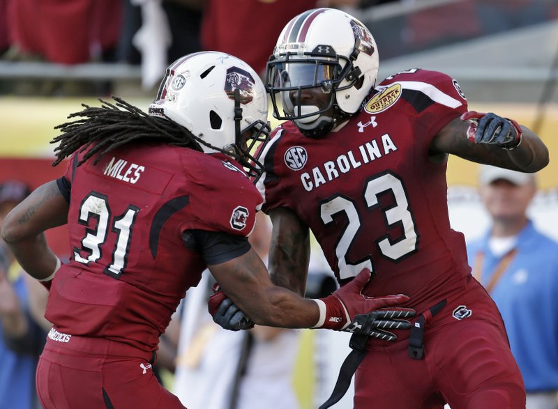 South Carolina wide receiver Bruce Ellington (23) celebrates with teammate Kenny Miles (31) after scoring on a 32-yard touchdown reception during the second half of the Outback Bowl NCAA college football game against Michigan, Tuesday, Jan. 1, 2013, in Tampa, Fla. South Carolina won 33-28. (AP Photo/Chris O'Meara)