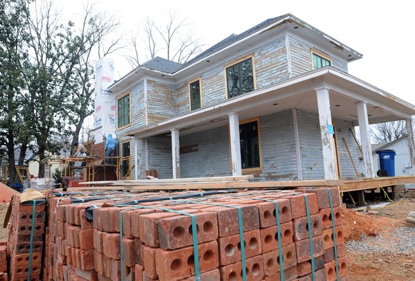 Workers remodel a house Friday at Southwest C and Southwest Fourth streets in Bentonville. 