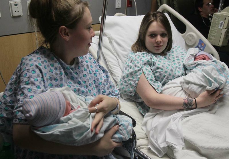 Twin mothers Aimee, left, and Ashlee Nelson hold their newborn sons Donavyn Bratten, left, and Aiden Lee Alan Dilts at Summa Akron City Hospital on Monday, Dec. 31, 2012, in Akron, Ohio. The mothers, 19, gave birth about two hours apart.