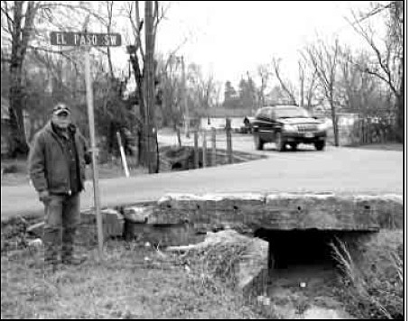 Tim DeWitt, Street and Utililties Director for the City of Gravette, stands at the intersection in Gravette where work will begin soon to help correct a storm water drainage problem.