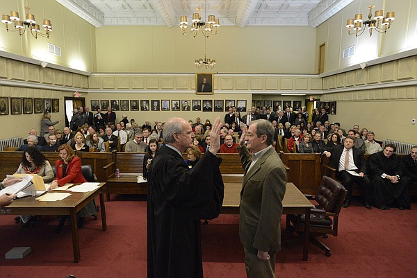 Doug Schrantz, left, Benton County Circuit Judge, swears in Benton County District 1 Justice of the Peace Mike McKenzie on Wednesday at the Benton County Courthouse in Bentonville. McKenzie was one of six freshmen justices of the peace who took their oaths along with the county’s nine returning justices of the peace. 