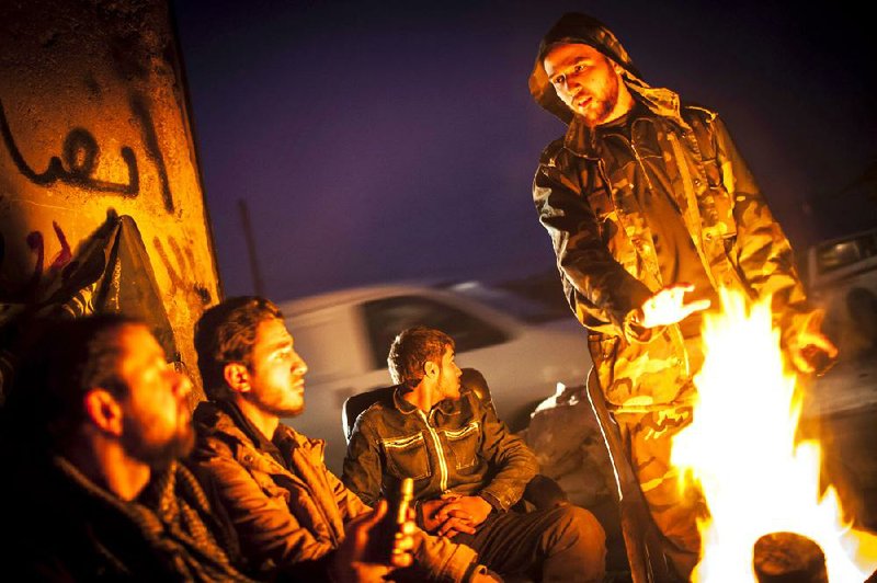 Syrian rebels gather around a fire as they plan patrols in the Saif al-Dawlah neighborhood of Aleppo, Syria, Wednesday, Jan. 2, 2013. The United Nations estimated Wednesday that more than 60,000 people have been killed in Syria's 21-month-old uprising against authoritarian rule, a toll one-third higher than what anti-regime activists had counted. The U.N. human rights chief called the toll "truly shocking." (AP Photo/Andoni Lubaki)