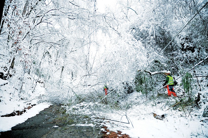 West Tree Service workers pick through a maze of downed trees, limbs and wires Dec. 27 in Hot Springs. Similar scenes were common across the Tri-Lakes region following a powerful winter storm that dumped a combination of rain, freezing rain, sleet and snow on the area.