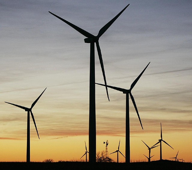 A windmill (rear center) supplies water to a stock tank, surrounded by wind turbines of the Smoky Hills Wind Project near Wilson, Kan. 