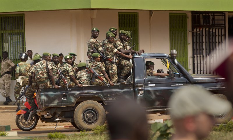 Government security forces in a pickup truck drive past a demonstration held by several hundred merchants calling for peace as negotiators prepare for talks with rebels from the north, in downtown Bangui, Central African Republic Saturday, Jan. 5, 2013. The U.N. Security Council urged rebels in the Central African Republic on Friday to halt their military offensive, withdraw from cities they have seized, and take part in negotiations to find a political solution to the impoverished country's longstanding problems.