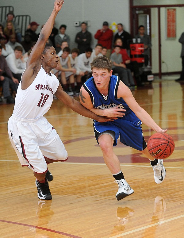 Keifer Holt, right, of Rogers High drives around Treshawn Gause of Springdale High during the second half of the game Friday at Springdale High School. Springdale beat Rogers in a mercy rule win, 79-49. 