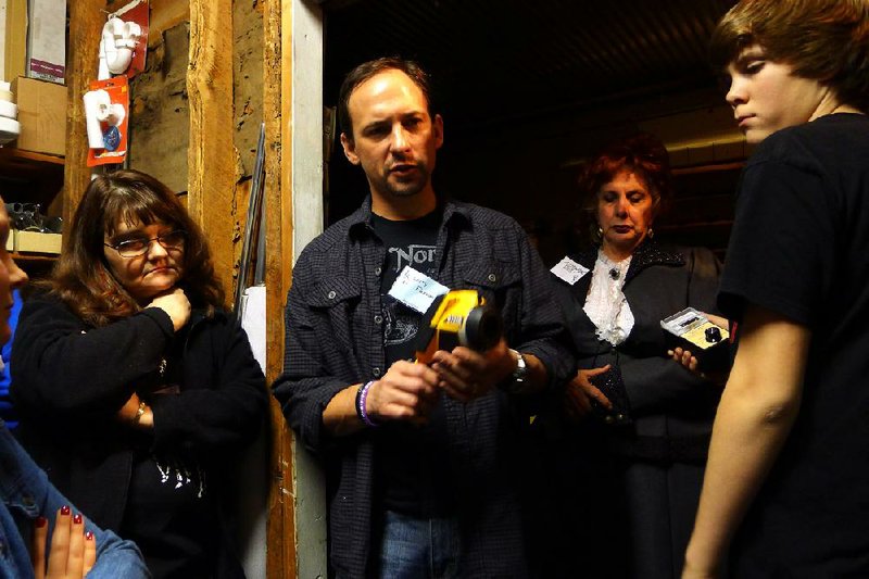 Larry Flaxman of Little Rock (second from left) uses a thermal camera Saturday morning to check for paranormal activity in the basement of the Crescent Hotel in Eureka Springs. The room once served as a hospital morgue. 