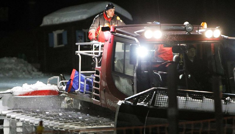 Rescue workers on a snowmobile early Saturday remove the bodies of six people who died in a sled crash late Friday in northeast Italy. 