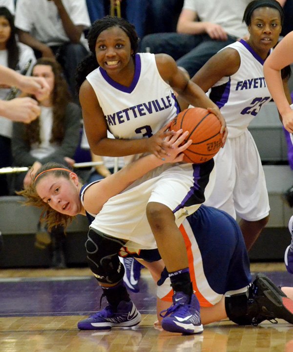 Jaylah Prude, Fayetteville guard, fights for control of the ball Friday against Rogers Heritage guard Brittany Ward at Bulldog Arena in Fayetteville. 