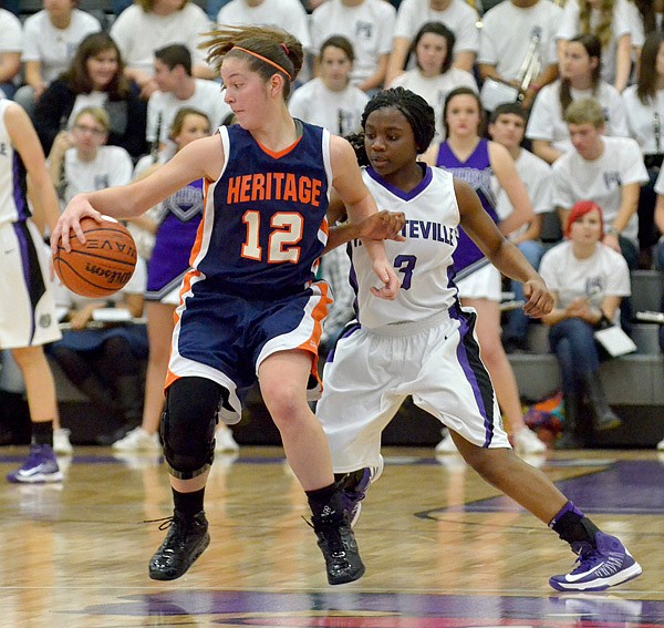 Brittany Ward, Rogers Heritage guard, tries to spin past Fayetteville defender Jaylah Prude on Friday at Bulldog Arena in Fayetteville. 