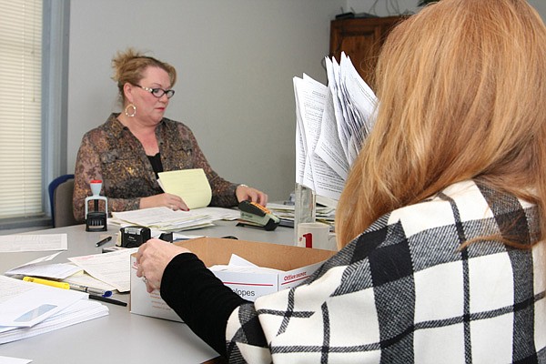 Peg Palmer, left, Low-Income Home Energy Assistance Program coordinator, and Karen Rakes, outreach coordinator, sort applications Thursday at the Office for Human Concern. An early mailing went to elderly and disabled people qualified by income for the program. General enrollment in the program begins Monday. 