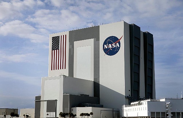 The NASA logo and U.S. flag mark the Vehicle Assembly Building at NASA Kennedy Space Center in Cape Canaveral, Fla. The 526-foot-tall structure is on NASA’s list to sell or lease. 