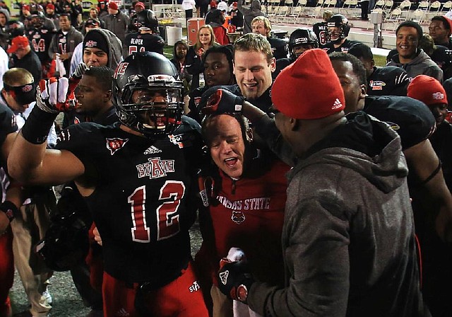 Interim Arkansas State coach John Thompson (center) celebrates the Red Wolves’ victory in the GoDaddy.com Bowl on Sunday with Kyle Coleman (12) and others. Thompson now returns to his duties as defensive coordinator for new coach Bryan Harsin. 
