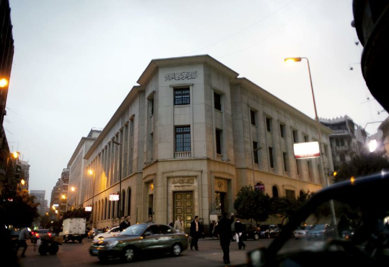 An Egyptian policeman directs traffic in front of the Egyptian Central Bank on Sunday in Cairo. 