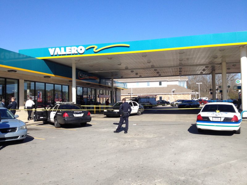 Little Rock police investigate the scene at a Valero gas station on the corner of Baseline and Stagecoach roads in Little Rock, where one of their own was hit by a vehicle while responding to a shoplifting call.