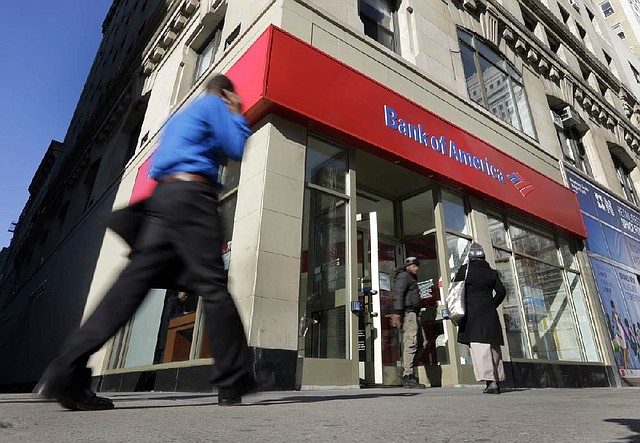 People pass a Bank of America branch Monday in New York. Bank of America will pay $10.3 billion to the government mortgage agency Fannie Mae to settle claims resulting from mortgage-backed investments that soured during the housing crash. 