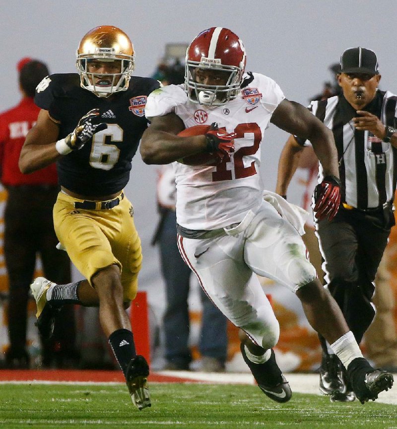 Alabama running back Eddie Lacy pulls away from Notre Dame’s KeiVarae Russell during the second half of Monday night’s BCS National Championship Game. Lacy led Alabama with 20 rushes for 140 yards, including a 20-yard touchdown run. He also caught an 11-yard touchdown pass from quarterback AJ McCarron. Lacy had more rushes than the entire Notre Dame team. 